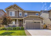 Beautiful two-story home featuring a well-manicured lawn and a two-car garage with stone accents at 12631 Glencoe St, Thornton, CO 80241