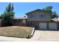 Charming two-story home with brick and siding, two car garage, and landscaped front yard at 12252 Elmendorf Pl, Denver, CO 80239