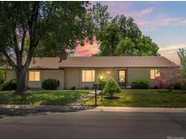 Charming ranch-style home with well-manicured lawn, mature trees, and cozy curb appeal showcased during a colorful sunset at 3780 W 66Th Ave, Arvada, CO 80003