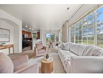 Bright living room boasts expansive windows, neutral tones, and views of kitchen and dining area at 101 Granby Way # B, Aurora, CO 80011