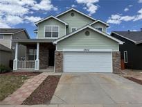 Charming two-story home with a two-car garage and inviting front porch at 20861 E 40Th Ave, Denver, CO 80249