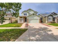 Inviting two-story home with a well-manicured lawn and attached two-car garage in a suburban neighborhood at 20861 E 40Th Ave, Denver, CO 80249