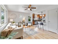 Bright living room featuring hardwood floors, ceiling fan, and open layout to the kitchen at 11433 Carlile St, Northglenn, CO 80233