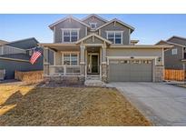 Charming two-story home with a cozy front porch and well-maintained lawn at 11078 Wheeling Ct, Commerce City, CO 80022