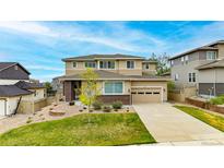 Inviting two-story home boasts a well-maintained lawn, charming brick accents, and an attached two-car garage at 4145 Manorbrier Cir, Castle Rock, CO 80104