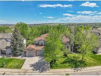 Charming two-story home featuring a well-manicured lawn, mature trees, and a spacious three-car garage at 1795 Eldorado Cir, Superior, CO 80027
