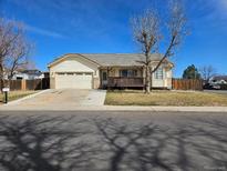 Charming single-story home boasts a spacious two car garage and inviting front porch, nestled on a well-maintained lawn at 808 Idalia St, Aurora, CO 80011