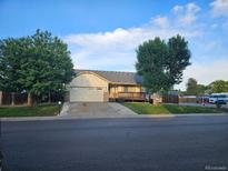 Charming single-Gathering home with a well-manicured lawn, mature trees, and a two-car garage at 808 Idalia St, Aurora, CO 80011