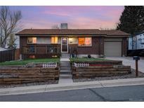 Charming brick home with a cozy front deck and landscaped yard featuring a retaining wall design at 11398 W Ford Pl, Lakewood, CO 80226