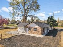Charming stone home with a well-maintained yard and mature trees offering shade and curb appeal at 16130 Mt Vernon Rd, Golden, CO 80401