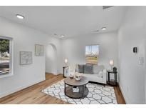 Bright living room featuring hardwood floors, white walls, a modern sofa and a decorative rug at 16130 Mt Vernon Rd, Golden, CO 80401