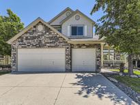 Charming two-story home featuring a stone facade and a spacious three-car garage at 10904 Eagle Run Dr, Parker, CO 80138