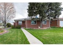 Charming brick home with a well-manicured front lawn and inviting walkway at 5582 E Colorado Ave, Denver, CO 80222