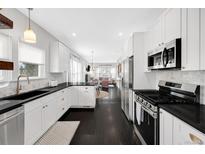 Modern kitchen features white cabinets, black countertops, and stainless steel appliances at 1402 Meade St, Denver, CO 80204