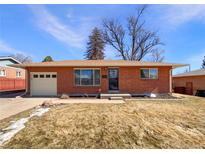 Charming brick home featuring an attached garage, landscaped yard, and classic architectural details at 3268 S Patton Ct, Denver, CO 80236