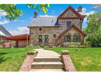 Charming stone house with a well-manicured lawn and unique architectural details at 3520 Newton St, Denver, CO 80211