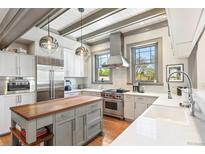 Modern kitchen featuring stainless steel appliances, a wooden island, and stylish pendant lighting at 3520 Newton St, Denver, CO 80211