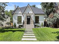 Charming white brick home with a black roof and manicured lawn at 1655 S Marion, Denver, CO 80210