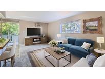 Bright living room featuring a plush blue sofa, large window, and stylish decor creating a cozy atmosphere at 937 N Clarkson St # 206, Denver, CO 80218