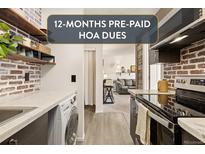 Kitchen features brick walls, marble countertops, and modern appliances, including a washer/dryer at 3035 Oneal Pkwy # 36T, Boulder, CO 80301