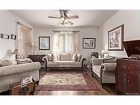 Comfortable living room featuring neutral furniture, hardwood floors, ceiling fan, and natural light at 7514 Blue Water Dr, Castle Rock, CO 80108