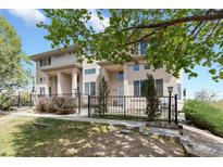 Inviting townhome with meticulous landscaping, fenced yard, and covered entry showcasing a well-maintained exterior at 14058 E Temple Dr, Aurora, CO 80015