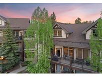 Beautiful exterior view of townhomes with private balconies and mountain views at sunset at 33 Broken Lance Dr # 207S, Breckenridge, CO 80424