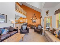 Bright living room with vaulted ceilings, leather furniture, and an open floor plan to kitchen and dining area at 33 Broken Lance Dr # 207S, Breckenridge, CO 80424