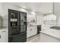 Modern kitchen featuring white cabinets, stainless steel appliances, marble countertops, and subway tile backsplash at 180 W 78Th Pl, Denver, CO 80221