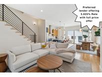 Bright, open living room flows to kitchen and dining area featuring modern staircase and hardwood floors at 2244 S Lincoln St, Denver, CO 80210