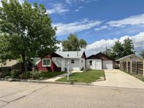 Charming single-story home with a well-maintained lawn, detached garage, and inviting curb appeal at 131 2Nd St, Fort Lupton, CO 80621