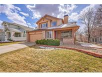 Charming two-story home with a well-manicured front lawn and attached two-car garage at 18736 E Powers Pl, Aurora, CO 80015