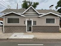 Charming single-story exterior showcasing a brick foundation and a symmetrical front façade with large windows at 421 E Alameda Ave, Denver, CO 80209