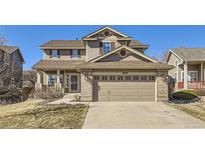 Charming two-story home features a well-manicured lawn, neutral siding, and a spacious two-car garage at 10273 Bentwood Ln, Highlands Ranch, CO 80126