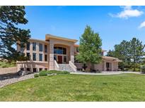 Stunning two-story home showcasing a well-manicured lawn, landscaped garden, and inviting staircase at 69 N Ranch Rd, Littleton, CO 80127