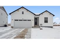 Stunning ranch-style home with a white exterior and a gray garage door at 803 Goodrich Peak St, Erie, CO 80516