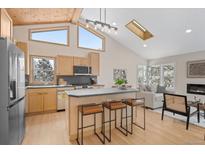 Bright, open kitchen featuring light wood cabinets, island seating, and vaulted ceilings at 342 Brook Cir, Boulder, CO 80302