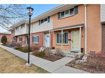 Charming townhome with a brick facade, sidewalk, and well-maintained landscaping creates a welcoming curb appeal at 9207 E Mansfield Ave, Denver, CO 80237