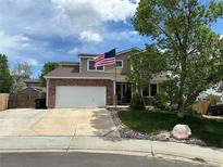 Charming two-story home with a well-maintained lawn, landscaped yard, and an American flag at 10870 Crestone Needles Dr, Parker, CO 80138