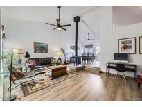 Bright living room features a wood burning stove, high ceilings and sleek ceiling fan at 2923 W Bryant Cir, Littleton, CO 80120