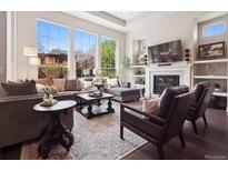 Bright living room features large windows, fireplace, and hardwood floors at 6970 E Lake Dr, Centennial, CO 80111