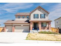 Charming two-story home featuring a three-car garage, brick accents, and a cozy front porch perfect for relaxing at 13742 Valentia St, Thornton, CO 80602