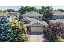 Charming two-story home featuring a well-maintained lawn, mature trees, and a two-car garage at 10532 Madison St, Thornton, CO 80233