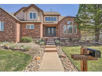 Stunning two-story brick home featuring a well-manicured front yard and elegant double-door entry at 18971 E Pinewood Dr, Aurora, CO 80016