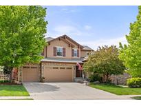 Charming two-story home with stone accents, a three-car garage, and a well-manicured lawn at 24702 E Ontario Dr, Aurora, CO 80016