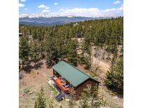 Mountain home featuring a metal roof, wood siding and a large deck with amazing views of the surrounding mountains and forest at 72 Rudi W Ln, Golden, CO 80403