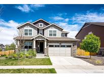 Charming two-story home with a stone facade, two-car garage, landscaped yard, and inviting front porch at 960 S De Gaulle Ct, Aurora, CO 80018