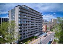 Modern high-rise apartment building with sleek architecture and balconies, set against a vibrant cityscape at 909 N Logan St # 6K, Denver, CO 80203