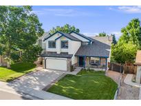 Charming two-story home with lush greenery, a spacious driveway, and well-maintained landscaping at 9147 W Rockland Pl, Littleton, CO 80128