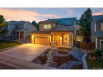 Charming two-story home featuring solar panels, a landscaped yard, and a welcoming front porch at 10015 Apollo Bay Way, Highlands Ranch, CO 80130